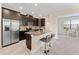 Kitchen with stainless appliances, granite countertops, dark wood cabinets, an island bar and an open floor plan at 11386 Biography Way, Orlando, FL 32832