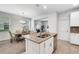 Open kitchen layout featuring a granite island with a stainless steel sink, and an adjacent dining space at 11386 Biography Way, Orlando, FL 32832