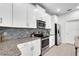 Modern kitchen featuring white cabinetry, stainless steel appliances, and a stylish backsplash at 11386 Biography Way, Orlando, FL 32832