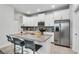 Modern kitchen featuring white cabinets, stainless steel appliances, and a spacious granite island with seating at 11386 Biography Way, Orlando, FL 32832