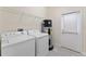 Bright laundry room includes appliances, storage shelving, and access to the outdoors, enhancing convenience and practicality at 11386 Biography Way, Orlando, FL 32832