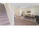 Living room with neutral walls, carpet flooring, stairs, and stylish furniture with a decorative rug at 11386 Biography Way, Orlando, FL 32832