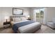 Comfortable staged bedroom with neutral color scheme, lamps on nightstands, and a view to a fenced yard at 1315 Lawndale Cp, Ormond Beach, FL 32174