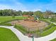Overhead shot of community playground featuring slides, swings, and a picnic shelter with a fenced border at 1315 Lawndale Cp, Ormond Beach, FL 32174