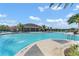 Spacious community pool with plenty of seating, umbrellas, and palm trees at 1315 Lawndale Cp, Ormond Beach, FL 32174