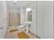 Bright bathroom featuring a glass enclosed shower, neutral tile, a pedestal sink, and linen closet at 150 E Robinson St # 2408, Orlando, FL 32801