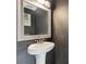 The half bath has a pedestal sink, a framed mirror, and is painted with modern colors at 1555 Seminole Run Rd, Osteen, FL 32764