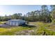 Large detached three-door garage with ample surrounding space and vehicle parking on a sunny day at 1555 Seminole Run Rd, Osteen, FL 32764
