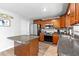 Charming kitchen features wooden cabinetry, stainless steel appliances, and an island with gray granite countertop at 1555 Seminole Run Rd, Osteen, FL 32764