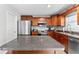 This kitchen boasts a stainless steel appliance package, wood cabinets, an island, and granite counter tops at 1555 Seminole Run Rd, Osteen, FL 32764