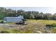 View of home, oversized detached garage, equipment, and the surrounding acreage at 1555 Seminole Run Rd, Osteen, FL 32764