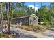 Home featuring a side entrance, concrete walkway, and grill surrounded by trees at 1611 Creekwood Run, Lakeland, FL 33809