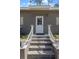Inviting front entrance featuring concrete steps and white railings, leading to a white door at 1611 Creekwood Run, Lakeland, FL 33809