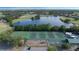 This aerial view shows the community tennis and basketball courts along the pond at 1710 Bridgets Ct, Kissimmee, FL 34744