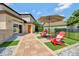 Backyard with red Adirondack chairs and brown umbrella on a well maintained lawn at 1710 Bridgets Ct, Kissimmee, FL 34744