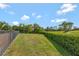 A meticulously maintained backyard, featuring a fence, green grass and view of golf course at 1710 Bridgets Ct, Kissimmee, FL 34744
