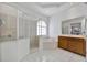 Bright bathroom featuring a glass shower, soaking tub, vanity, and white tiled floors at 1710 Bridgets Ct, Kissimmee, FL 34744
