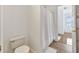 Small bathroom with a toilet, a shower with a white curtain, and doorway to the bedroom at 1710 Bridgets Ct, Kissimmee, FL 34744