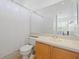 Clean and simple bathroom featuring a toilet, vanity, sink, and large mirror at 1710 Bridgets Ct, Kissimmee, FL 34744