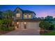 Charming two-story home with a three car garage and beautiful stone and brick facade at twilight at 1710 Bridgets Ct, Kissimmee, FL 34744