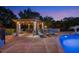 A gazebo with outdoor seating, lighting, brick fireplace, bar, and lounge chairs by the pool at 1710 Bridgets Ct, Kissimmee, FL 34744