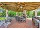 A cozy gazebo with a brick fireplace, bar, grill, outdoor seating, and unique lighting at 1710 Bridgets Ct, Kissimmee, FL 34744