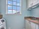 Bright laundry room with blue walls, cabinetry, stainless steel sink and a window at 1710 Bridgets Ct, Kissimmee, FL 34744