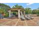 Covered outdoor living space with comfortable lounge chairs and dining area, near pool at 1710 Bridgets Ct, Kissimmee, FL 34744