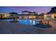 A gorgeous pool with a spa, waterfall features, patio seating, and lights at dusk at 1710 Bridgets Ct, Kissimmee, FL 34744