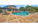A luxurious pool with a spa, waterfall feature, gazebo, and brick paved patio at 1710 Bridgets Ct, Kissimmee, FL 34744