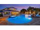 A luxurious pool with a spa, waterfall feature, gazebo, patio seating, and lighting at 1710 Bridgets Ct, Kissimmee, FL 34744