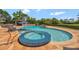 Luxury pool featuring a hot tub and waterfall. An outdoor cabana is set up for dining and entertaining at 1710 Bridgets Ct, Kissimmee, FL 34744