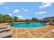 Luxury pool featuring a waterfall and sun loungers. An outdoor bar area is set up for dining and entertaining at 1710 Bridgets Ct, Kissimmee, FL 34744
