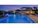 A gorgeous pool with a spa, waterfall feature, patio seating, and an outdoor bar at dusk at 1710 Bridgets Ct, Kissimmee, FL 34744