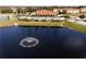 Aerial view of community pool and clubhouse with a pond with fountain in the foreground at 1802 Coriander Dr, Kissimmee, FL 34759