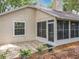 Charming backyard exterior featuring neutral stucco and stone tile patio and a screened-in porch at 1869 Eagles Rest Dr, Apopka, FL 32712