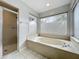 Bathroom featuring soaking tub with jets and a glass enclosed shower at 1869 Eagles Rest Dr, Apopka, FL 32712