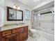 Cozy bathroom with granite vanity, stylish lighting, and a shower-tub combo with sliding glass doors at 1869 Eagles Rest Dr, Apopka, FL 32712