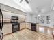 Modern kitchen with wood floors, stainless steel appliances, and open breakfast nook at 1869 Eagles Rest Dr, Apopka, FL 32712