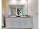 Modern bathroom featuring double sinks, granite countertop, white cabinets, and large mirror at 203 Taylor Groves Dr, Lake Wales, FL 33853