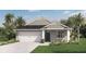 Charming single-story home featuring a two-car garage and a well-manicured lawn with tropical landscaping at 203 Taylor Groves Dr, Lake Wales, FL 33853