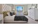 Relaxing main bedroom featuring a tufted headboard, accent chair, and bright window at 203 Taylor Groves Dr, Lake Wales, FL 33853