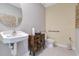 Stylish half bathroom with a modern sink, wooden cabinet, toilet, and decorative mirror at 203 Taylor Groves Dr, Lake Wales, FL 33853