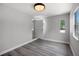 Bedroom with gray walls and wood-look flooring has a door leading to another room and natural light from two windows at 2105 9Th Ne St, Winter Haven, FL 33880