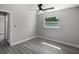 Bright bedroom featuring gray walls, ceiling fan, and gray wood-look flooring at 2105 9Th Ne St, Winter Haven, FL 33880