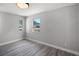 Bright bedroom features light gray walls, trim and gray wood-look flooring and natural light from two windows at 2105 9Th Ne St, Winter Haven, FL 33880