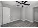 Bedroom featuring wood-look flooring, a ceiling fan, gray walls, a door and closet for storage at 2105 9Th Ne St, Winter Haven, FL 33880