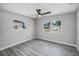 Bedroom featuring two windows allowing natural light, gray walls, and wood-look flooring at 2105 9Th Ne St, Winter Haven, FL 33880