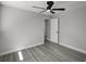 Bedroom with gray walls, wood-look flooring, a ceiling fan and a door leading to another room at 2105 9Th Ne St, Winter Haven, FL 33880