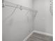 Walk-in closet with gray walls, wood-look flooring and white closet rods for plenty of storage at 2105 9Th Ne St, Winter Haven, FL 33880